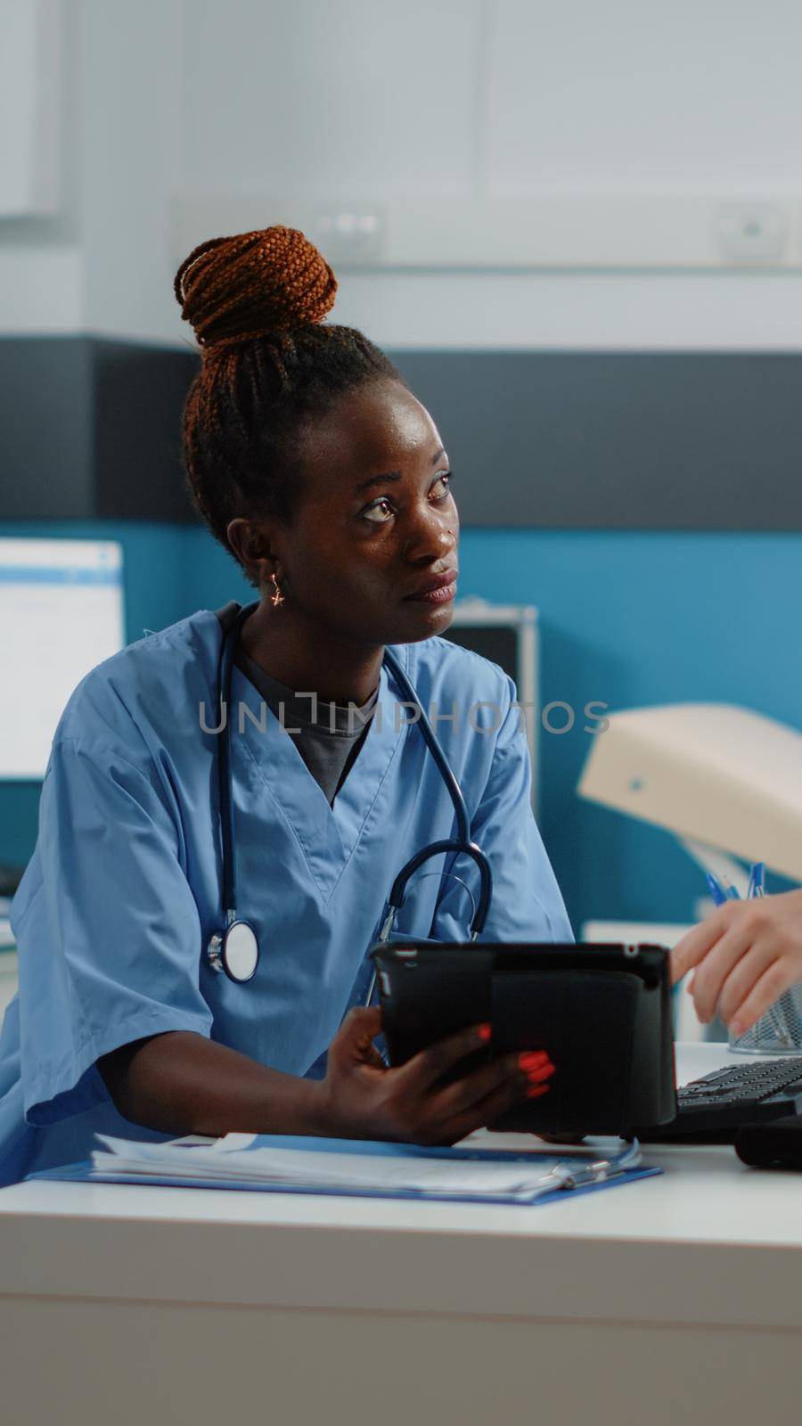 Medical team of nurses using tablet with touch screen in cabinet for examination and appointments. Group of assistants working with technology and equipment for healthcare and treatment