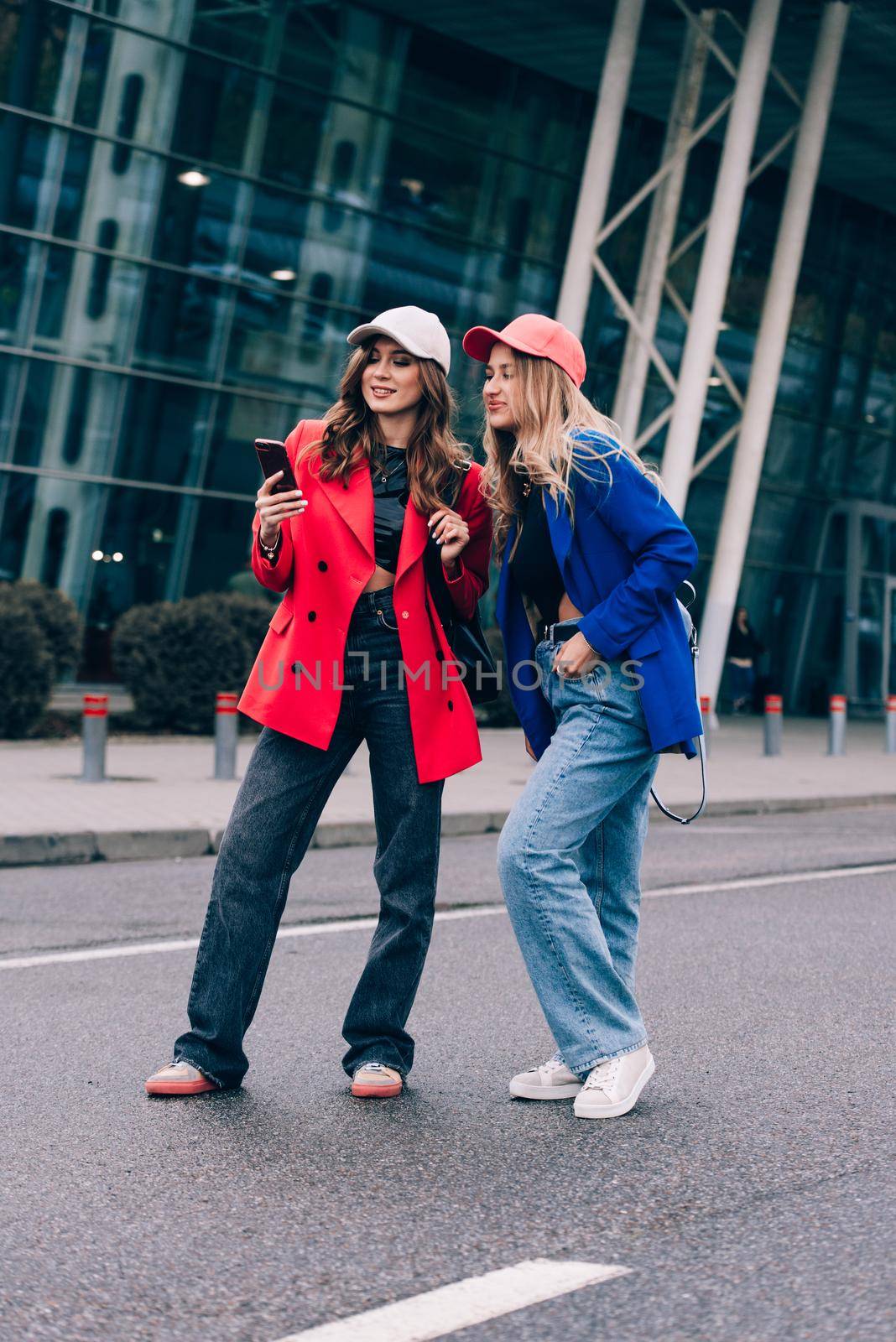 Two happy girls walking near airport. Air travel, summer holiday. Communication