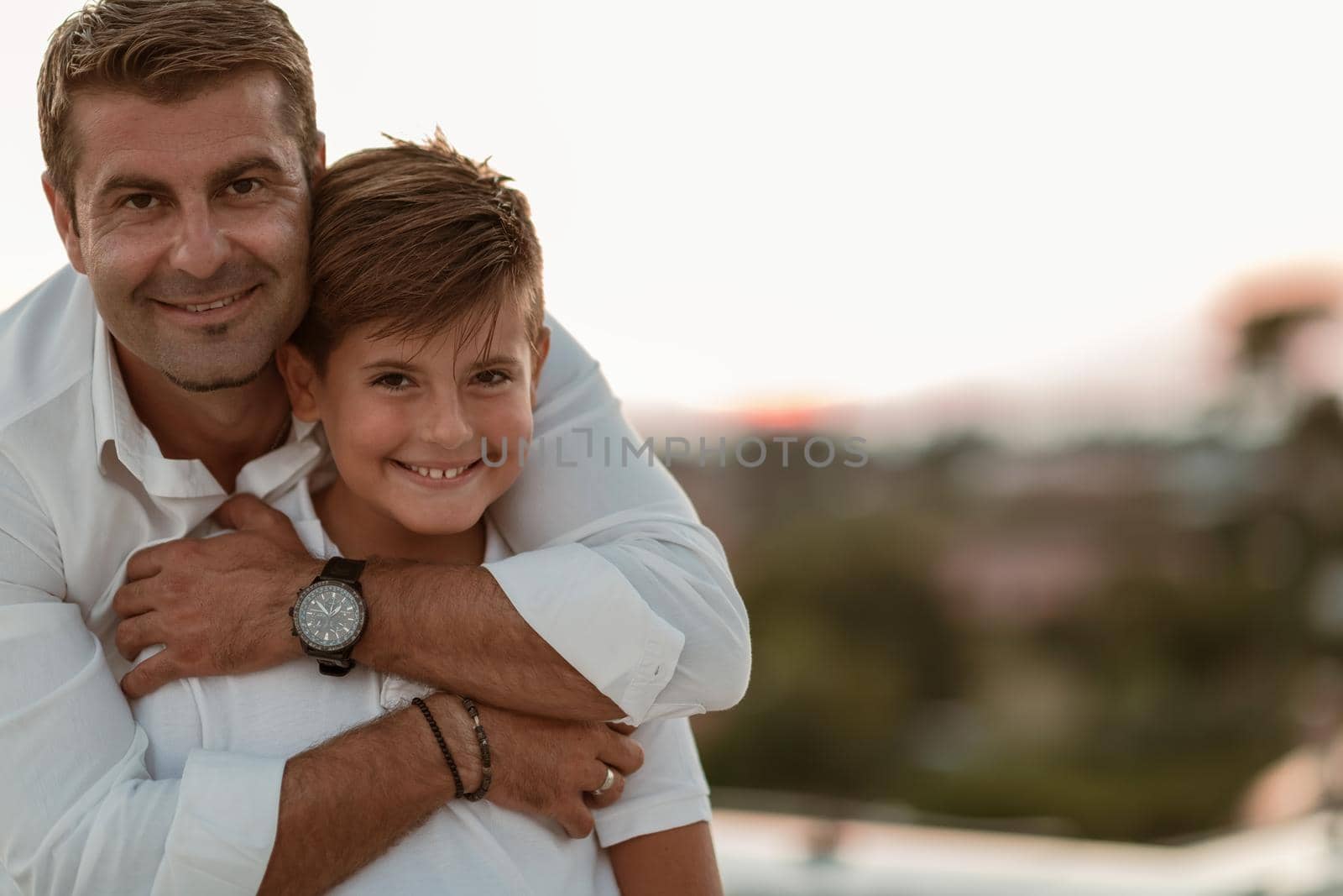 Father and son spend time together on the roof of the house while enjoying the sunset. Selective focus. High-quality photo