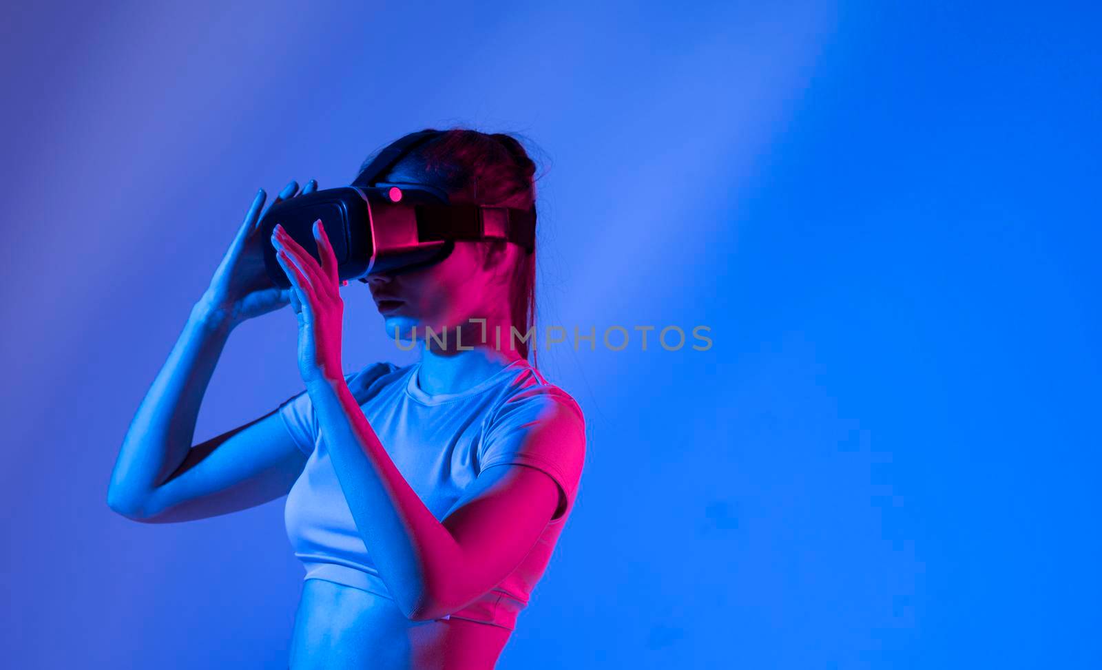 Woman experiencing virtual reality goggles in neon light. by vovsht