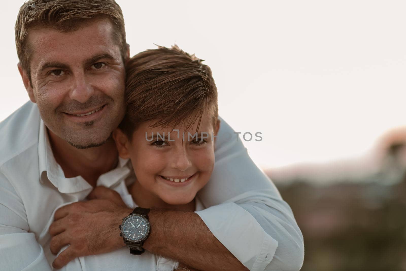 Father and son spend time together on the roof of the house while enjoying the sunset. Selective focus. High-quality photo
