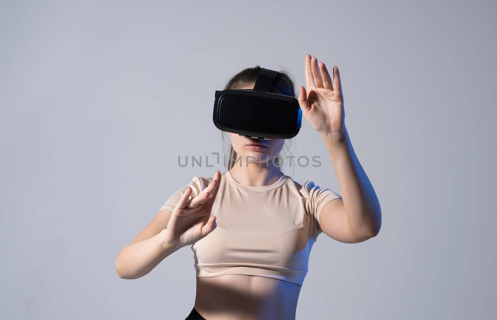 VR, augmented reality, science, future technology concept. Young brunette woman in glasses of virtual reality in neon light. Futuristic 3d glasses with virtual projection. by vovsht