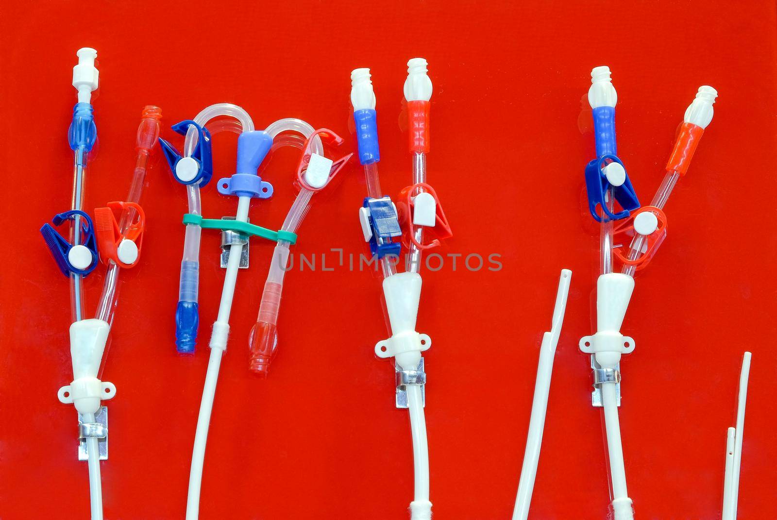 Tubes and hoses for use in bypass to patients with fatty stasis in the arteries. To make blood flow to the blood vessels and heart is normal, on red plastic sheet background