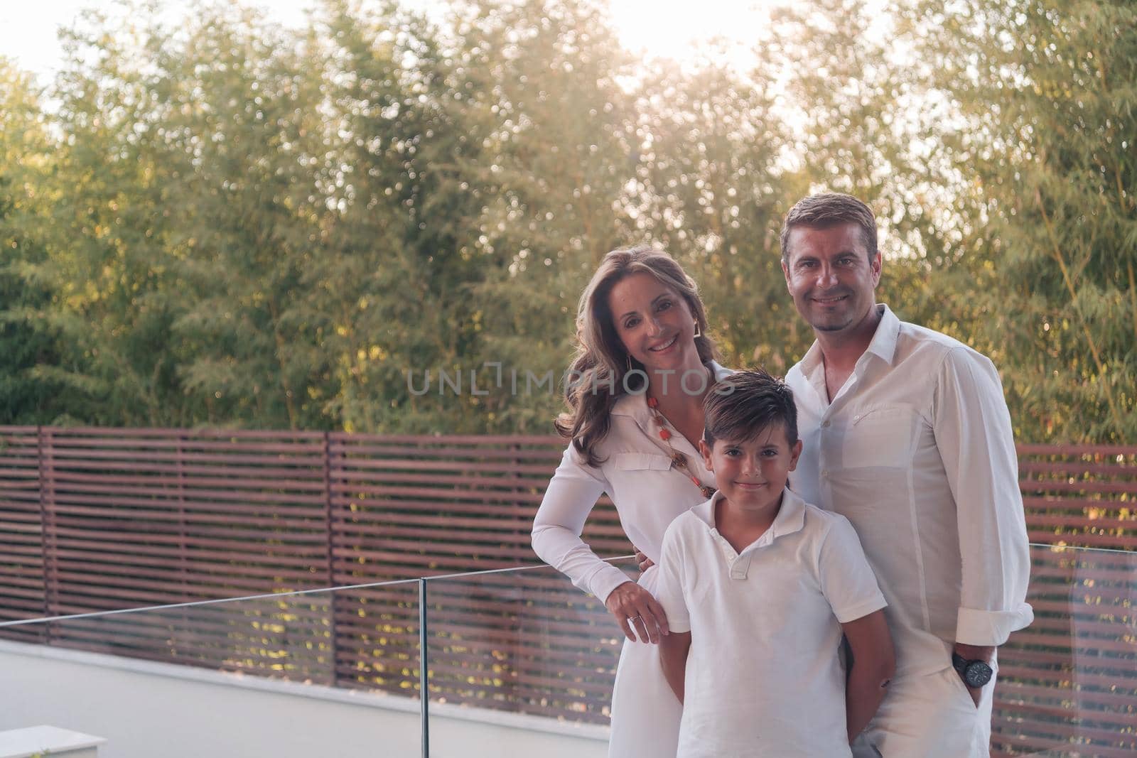 Happy family resting on the balcony of a luxury house surrounded by forest nature. Selective focus. High-quality photo