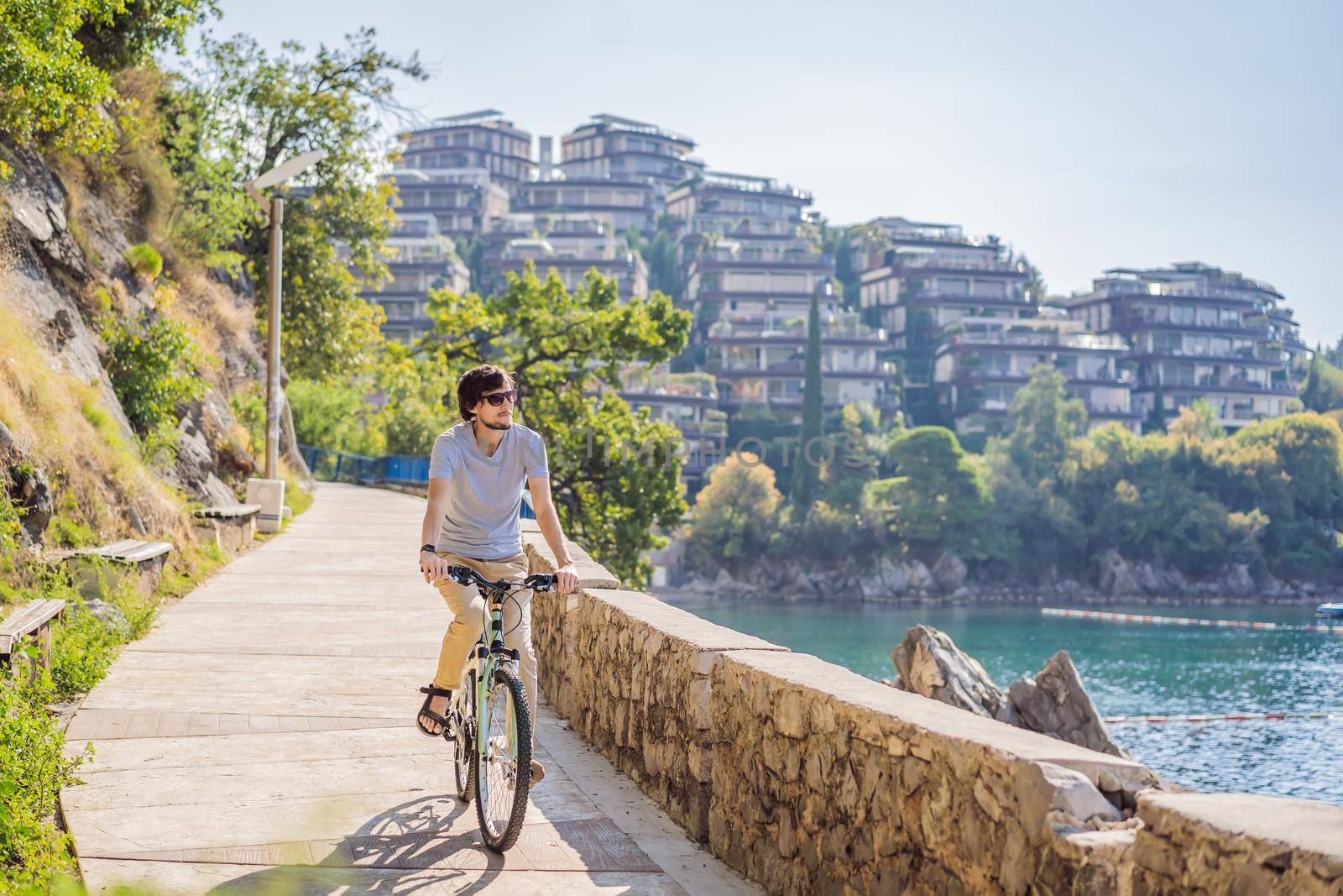 Man tourist on a bicycle explores Budva in Montenegro. Cycling in Montenegro concept by galitskaya