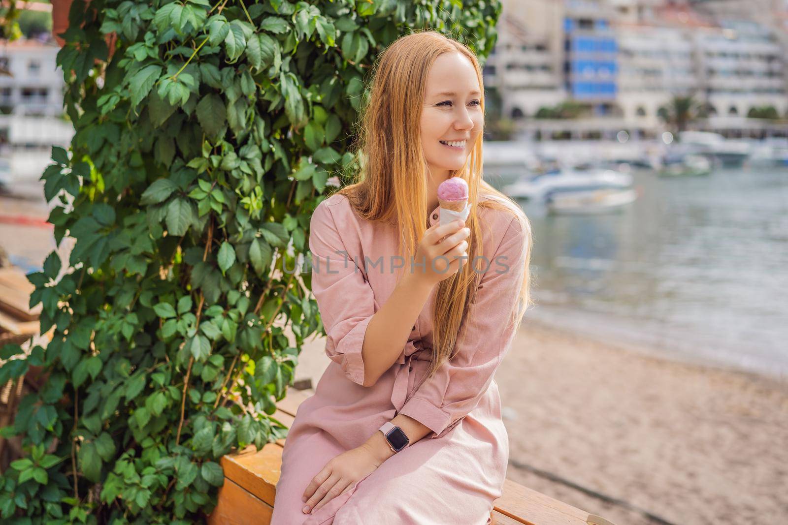 Close up of pretty tourist girl eating traditional gelato italian ice cream in a European town by galitskaya