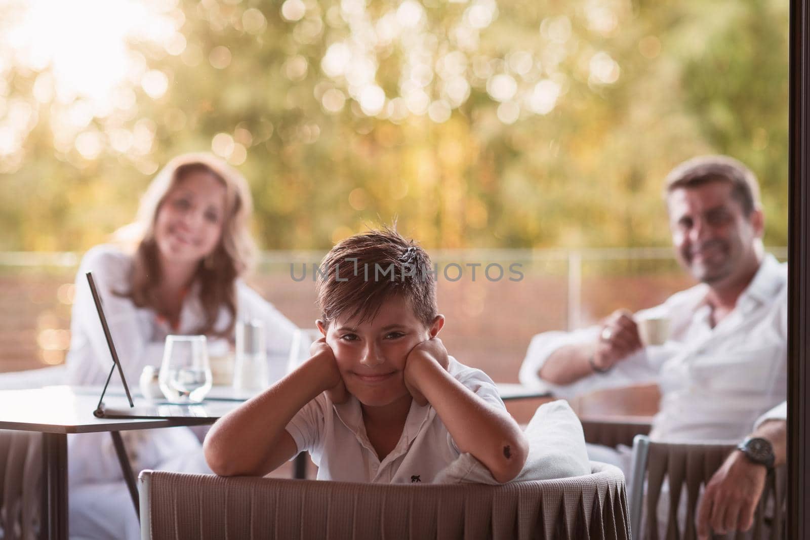 An elderly couple enjoys the terrace of a luxury house with their son during the holidays. Selective focus. High-quality photo