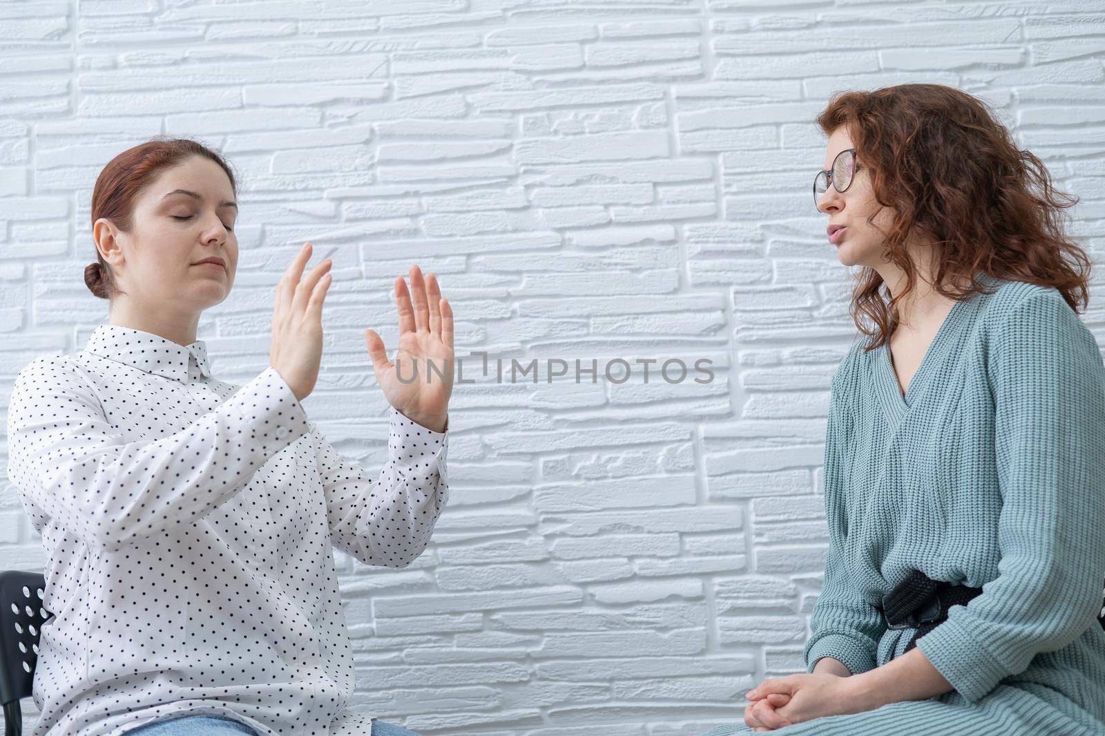 The psychotherapist conducts a hypnosis session. Female patient under hypnosis