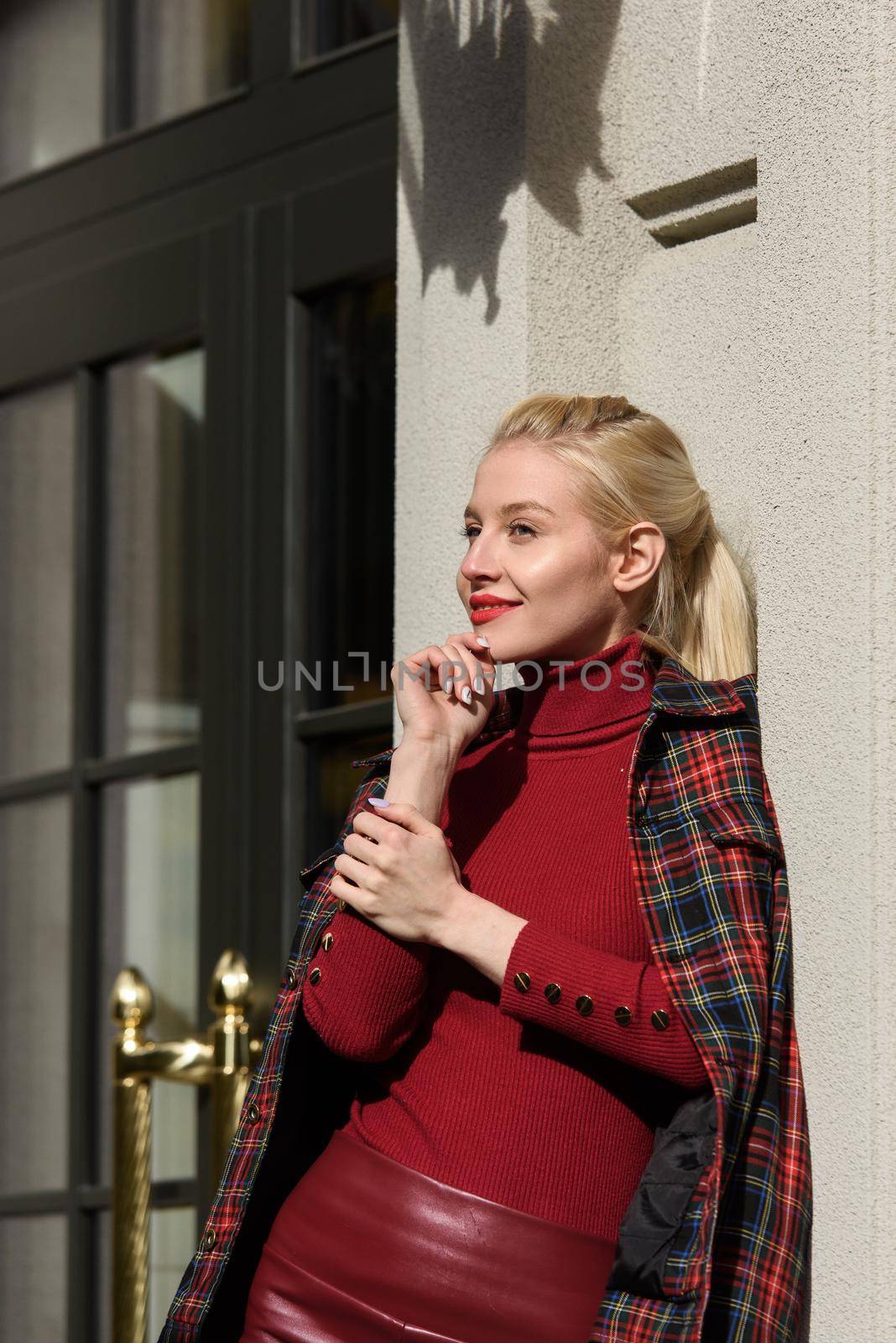 fashionable blonde girl with a red lipstick posing outdoors . Dressed in a red leather leggings, turtleneck and checkered jacket. fit figure by Ashtray25