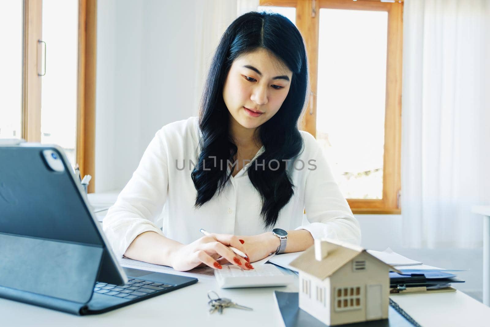 Entrepreneurs, business owners, accountants, real estate agents, Portrait of asian women who use the home buying budget calculator to calculate their financial risks. by Manastrong