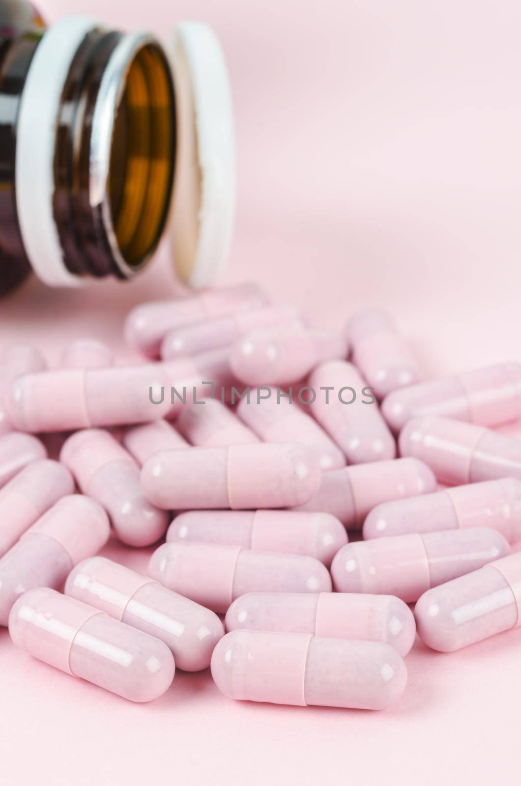 Pink capsule pills with bottle by Gamjai