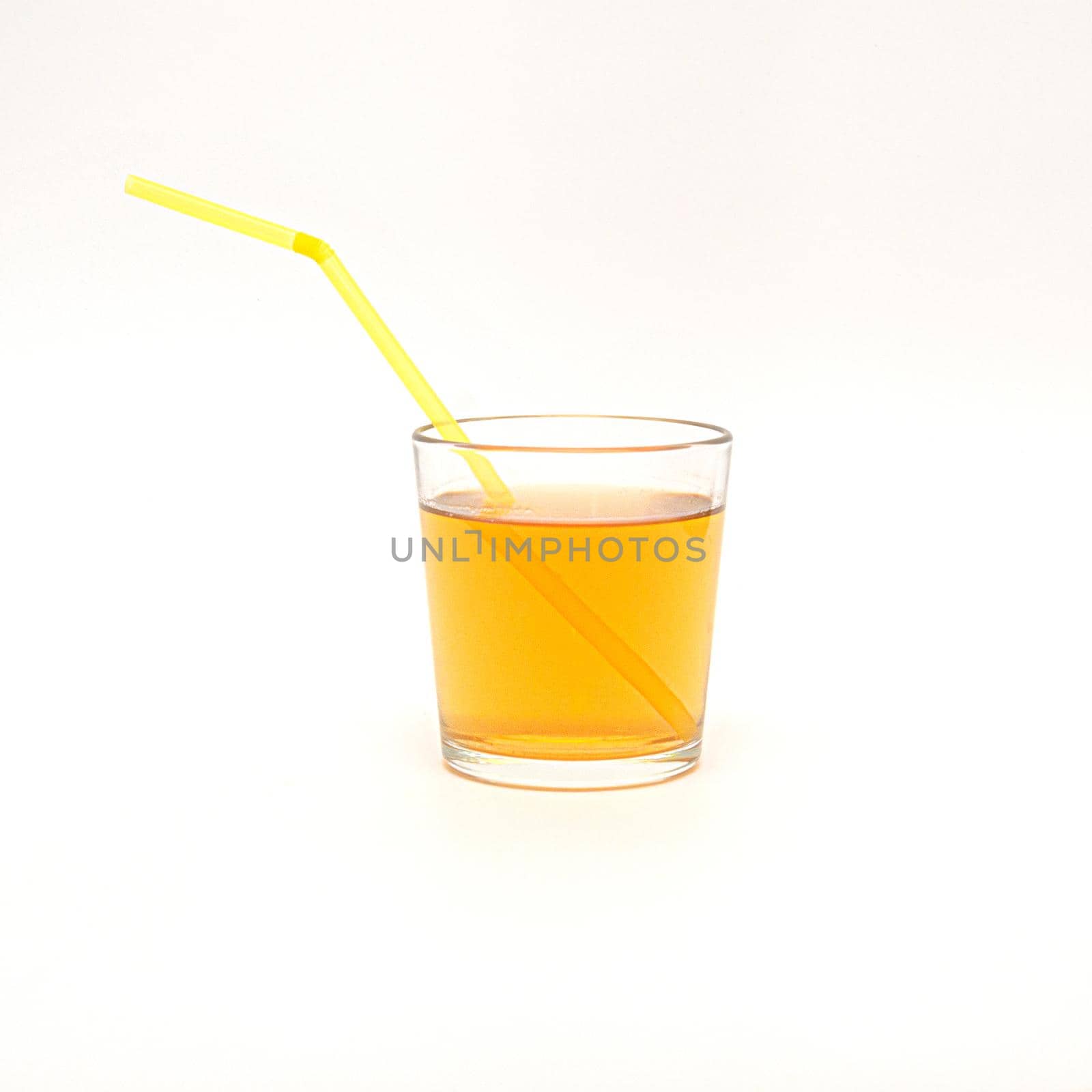 a glass of apple juice with a straws isolated on a white background,