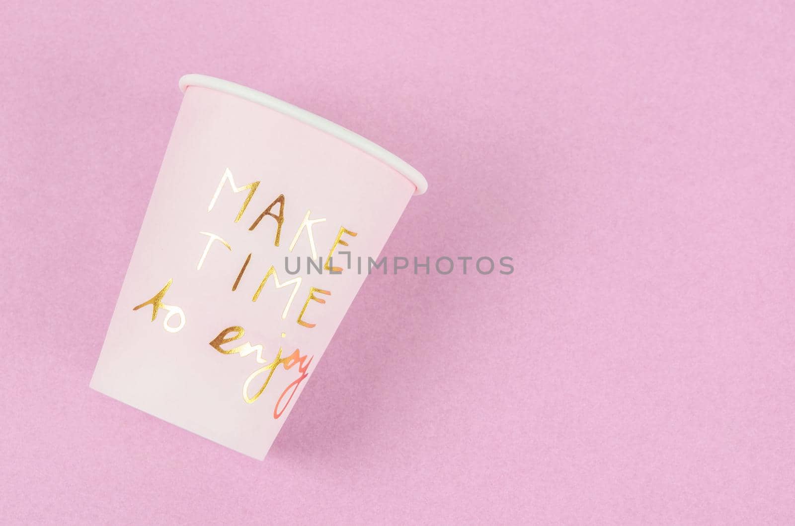 Wording Make time to enjoy on pink paper cup on pink background.