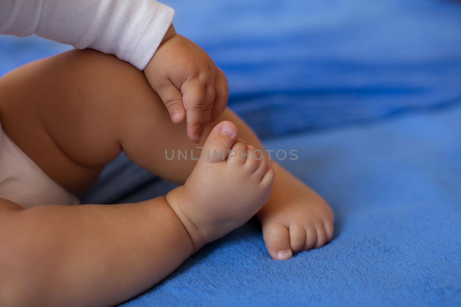 Children's legs on a blue veil close-up