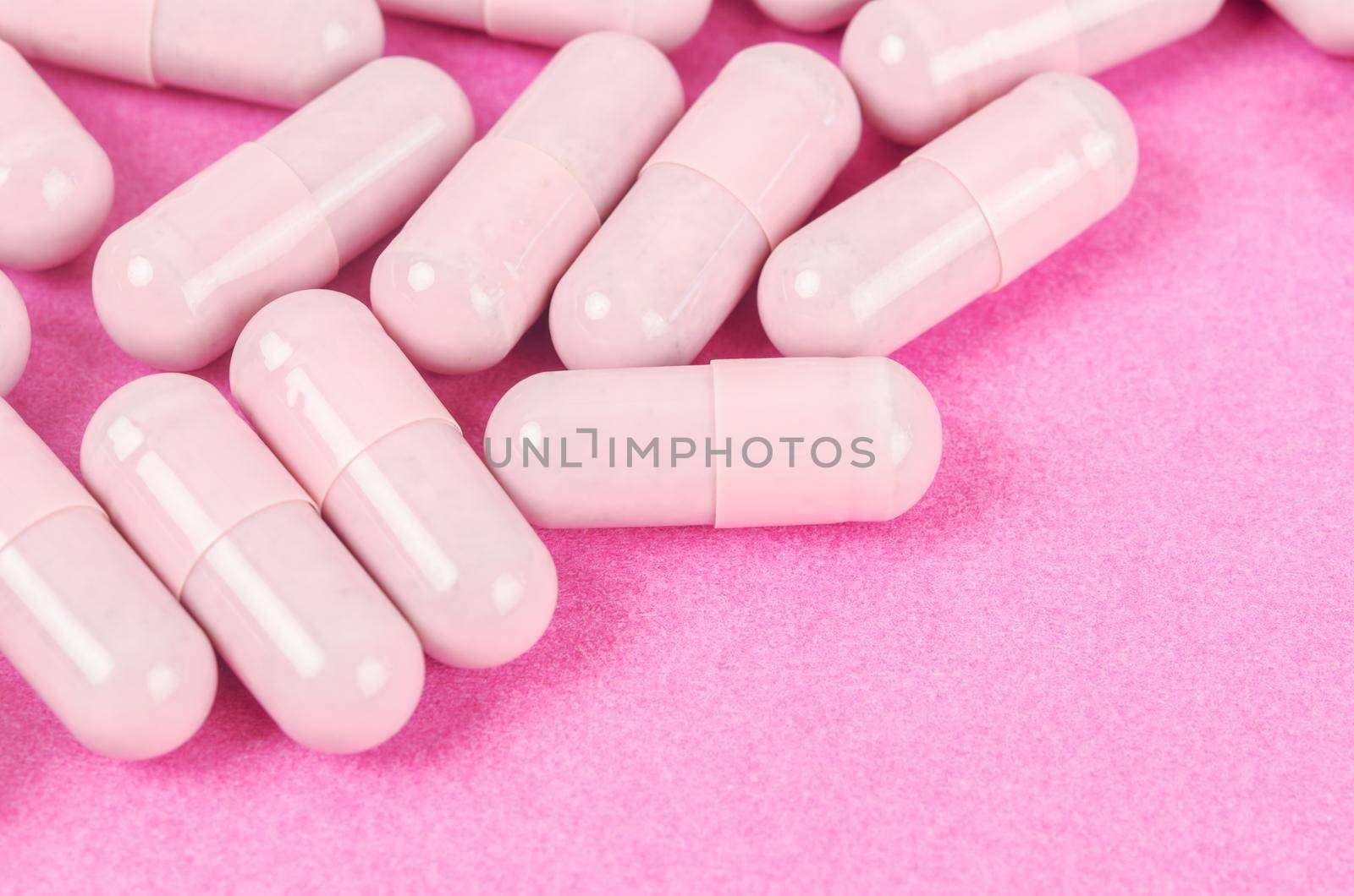 The Pink capsule pills on pink background