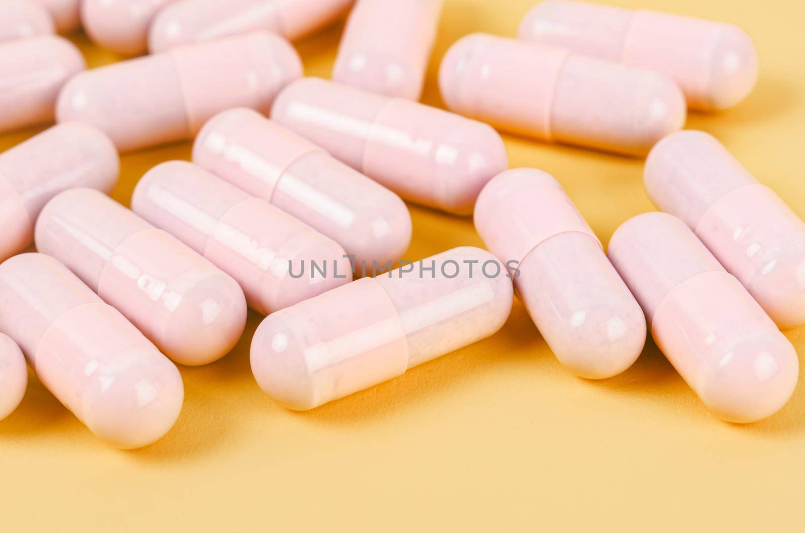 The Pink capsule pills on yellow background