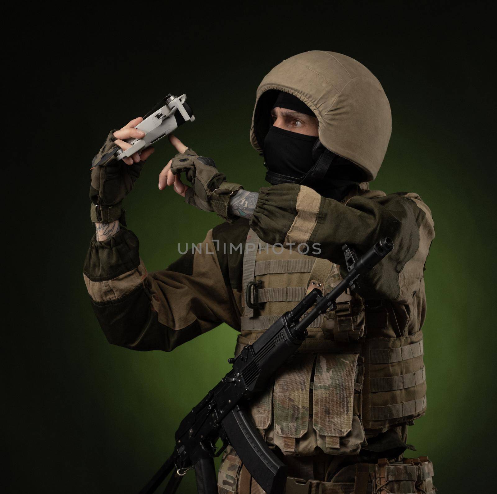 a soldier in military clothes with a weapon launches a small unmanned quadcopter for reconnaissance on a dark background by Rotozey