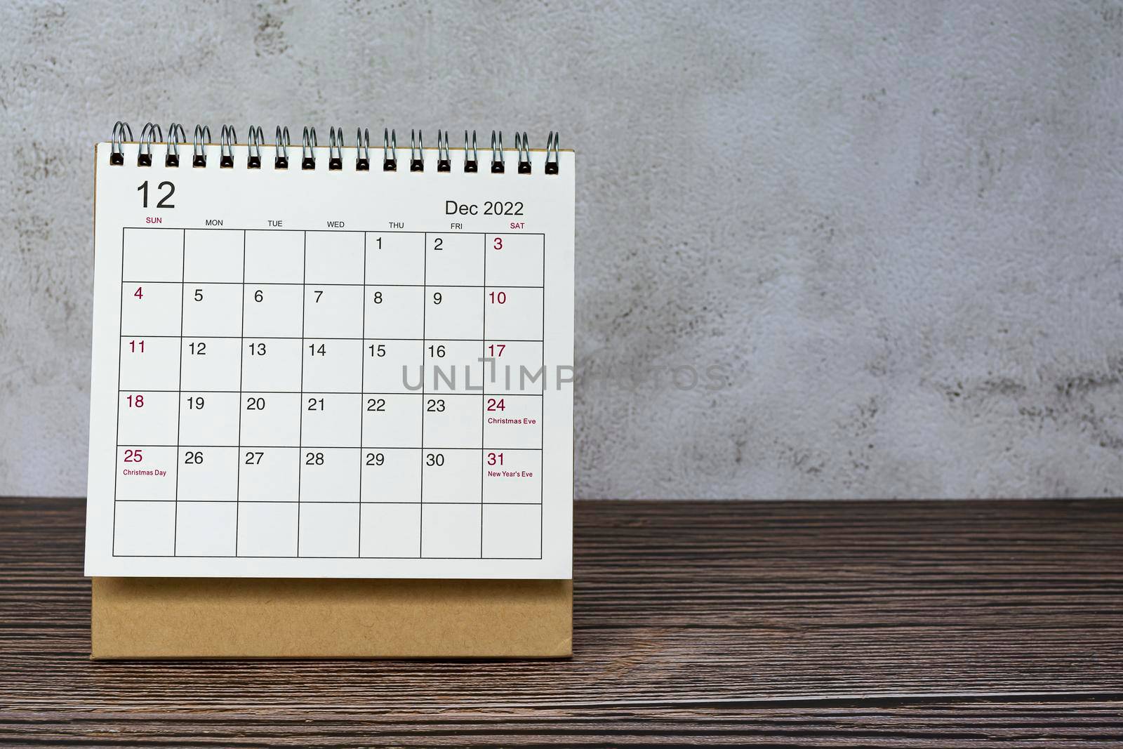 December 2022 white calendar on wooden desk. Celebration date and copy space.