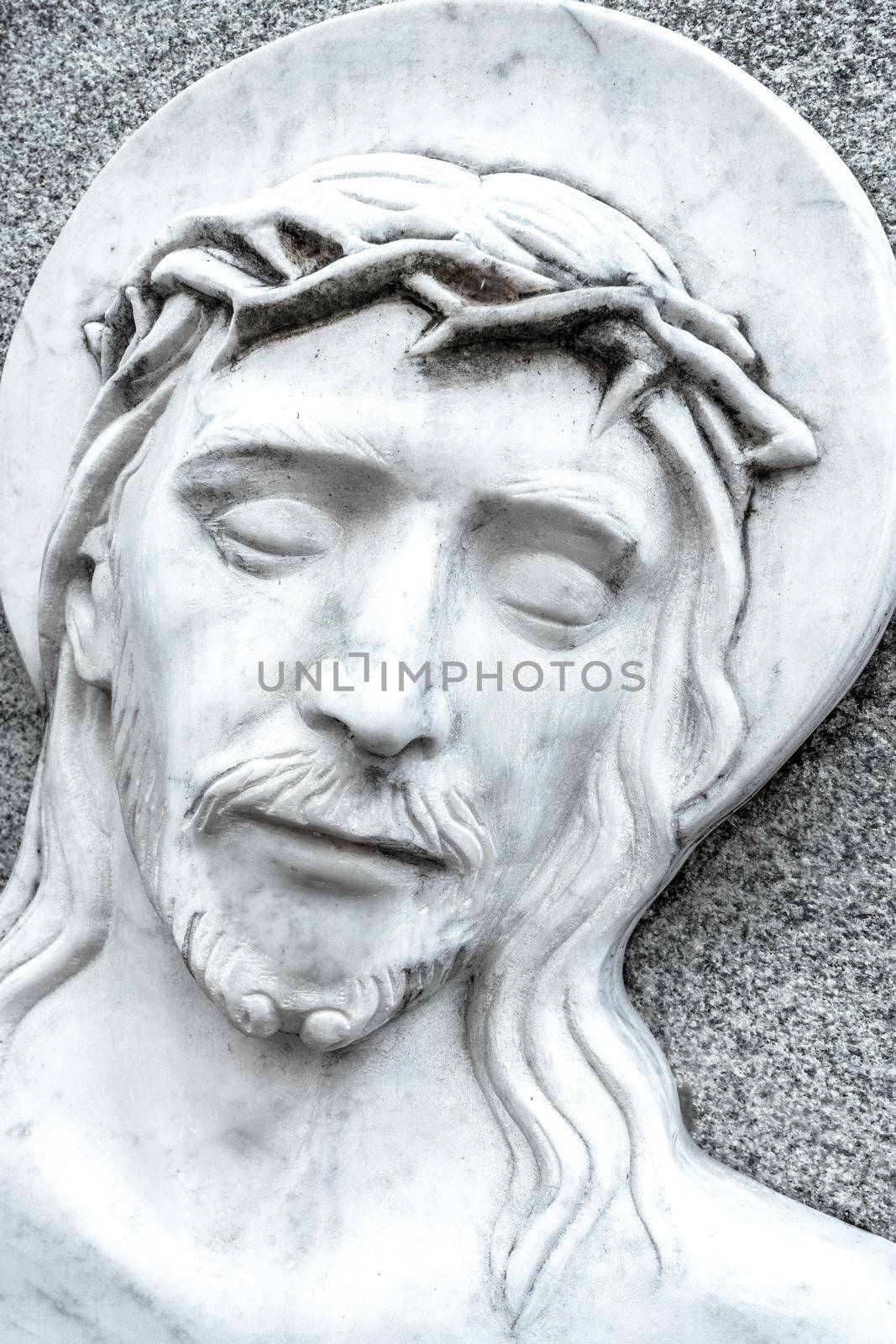 The face of Jesus Christ suffering on the cross. Bas relief.