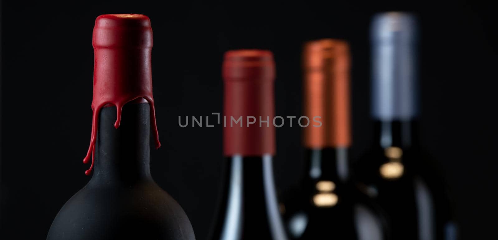 Set of collars red wine bottles isolated on black background, France