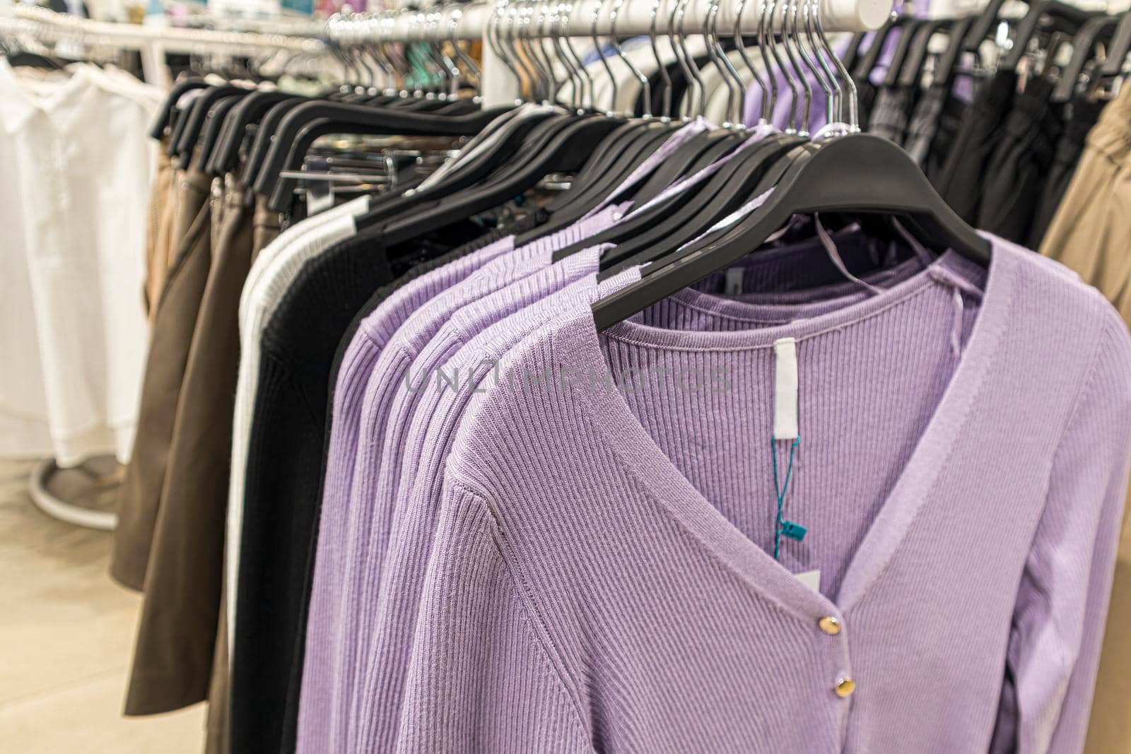 women's sweaters on hangers in a large store. photo