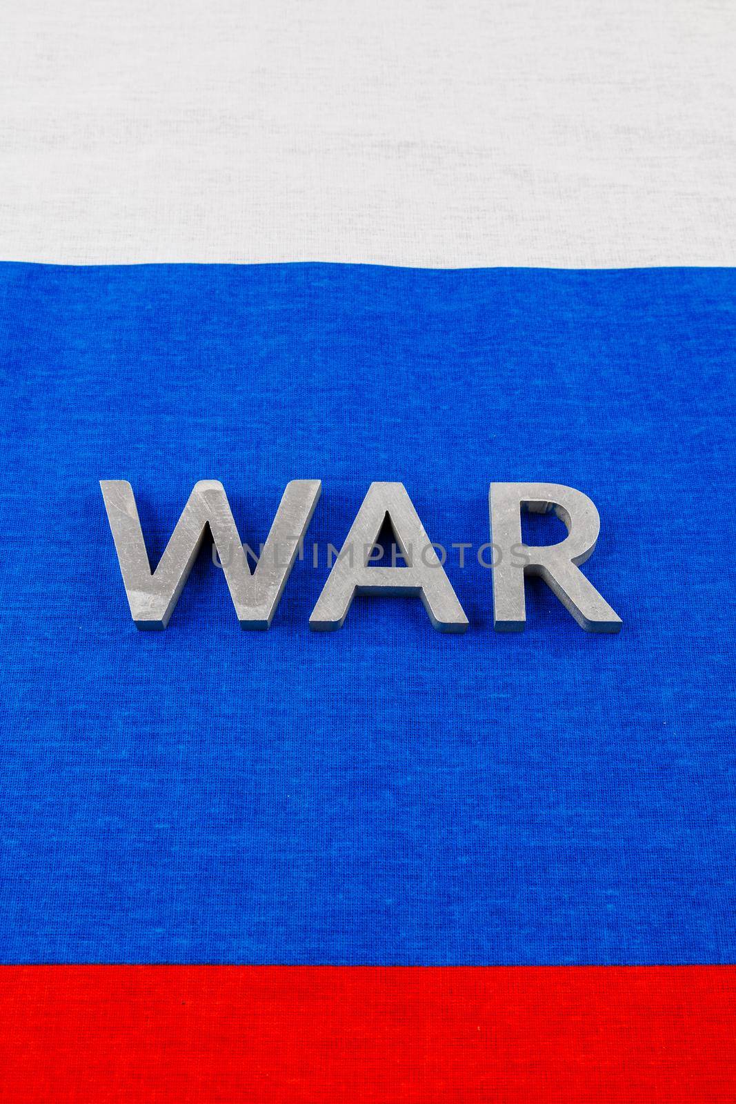 the word war laid with silver metal letters on Russian Federation tricolor flag - full-frame view