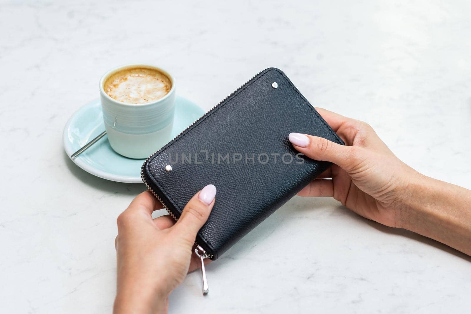 Black wallet near the coffee cup on a white table by wip3out