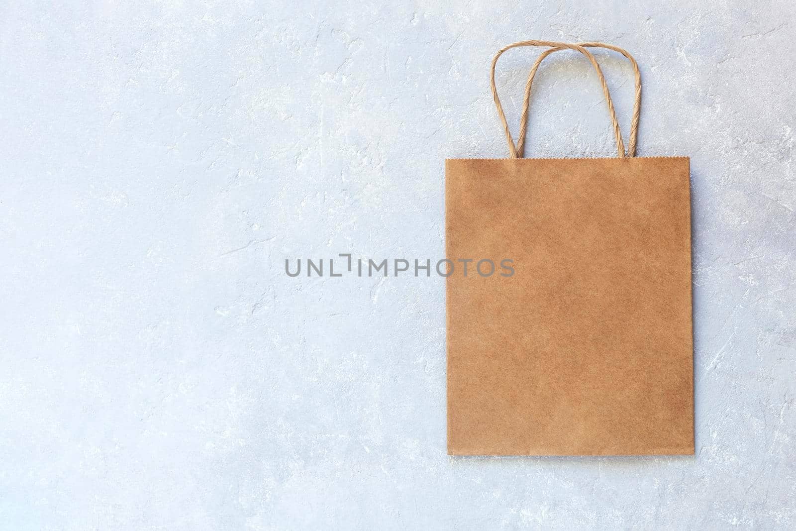 craft paper bag on the grey concrete background, top view, copyspace, zero waste concept,