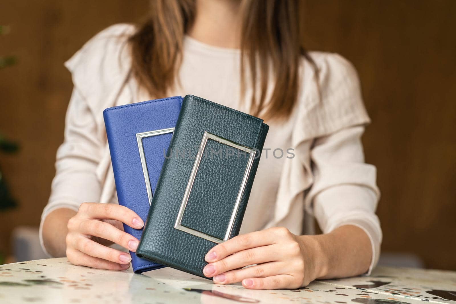 Two wallets in the hands of a girl in white