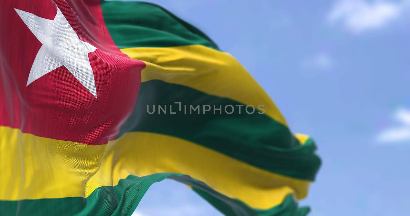 Detail of the national flag of Togo waving in the wind on a clear day. Togo is a country in West Africa. Selective focus.