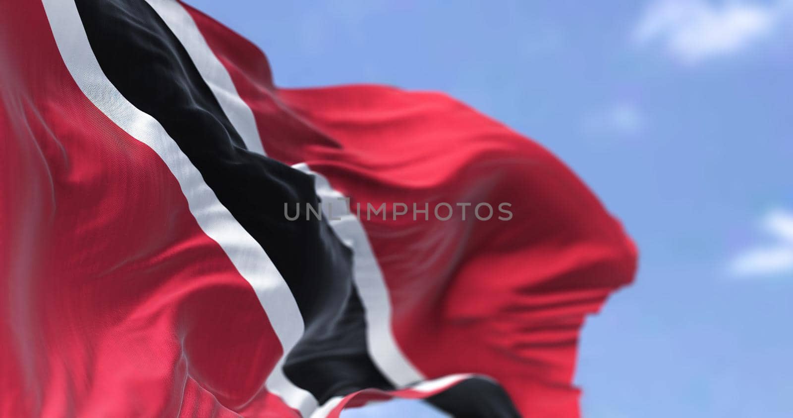 Detail of the national flag of Trinidad and Tobago waving in the wind on a clear day by rarrarorro