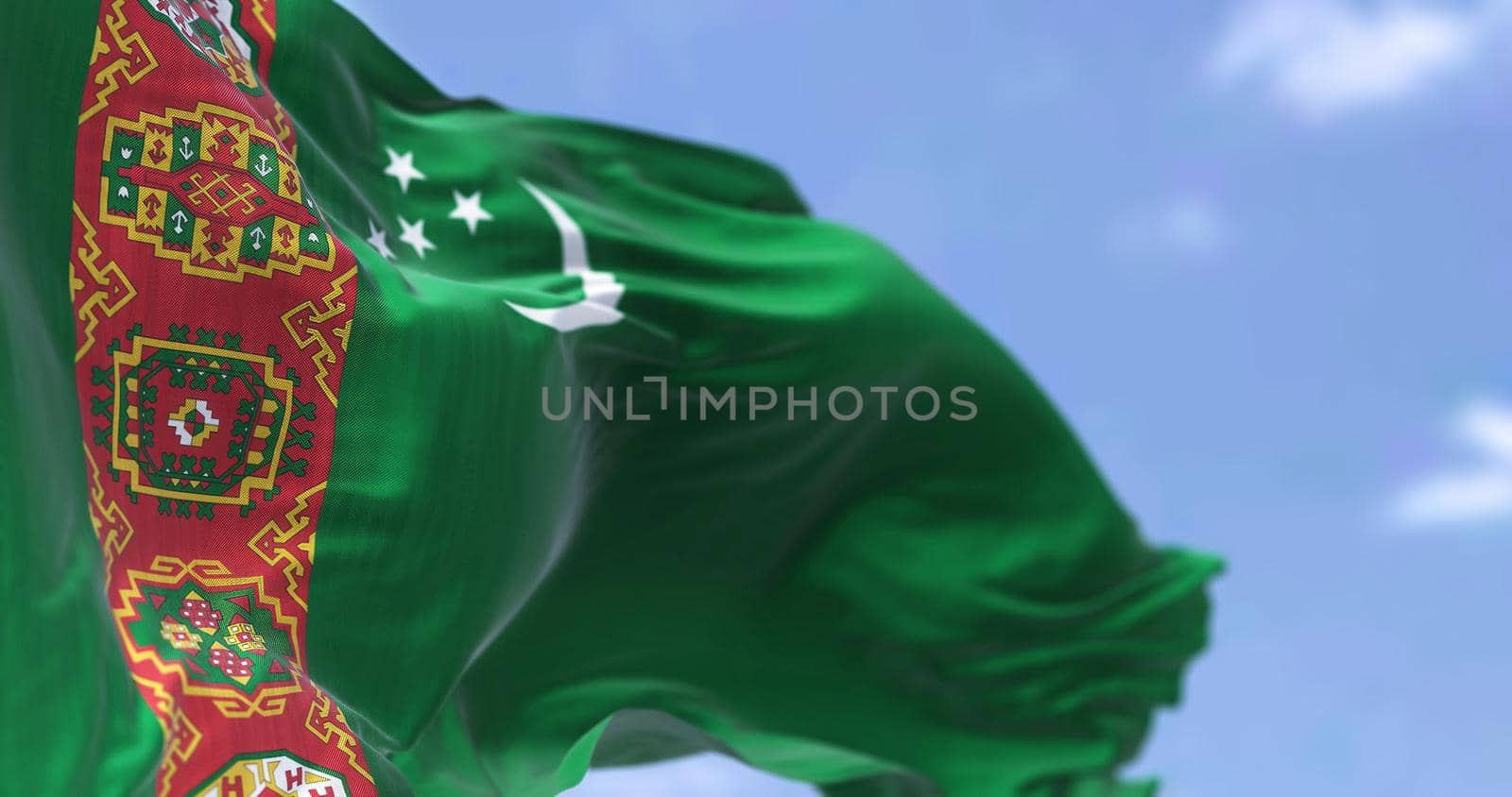 Detail of the national flag of Turkmenistan waving in the wind on a clear day. Turkmenistan is a landlocked country in Central Asia. Selective focus.