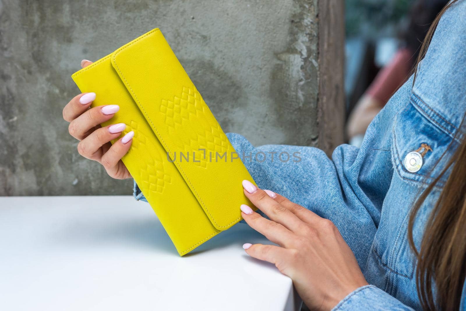 Yellow wallet on the table in the girl's