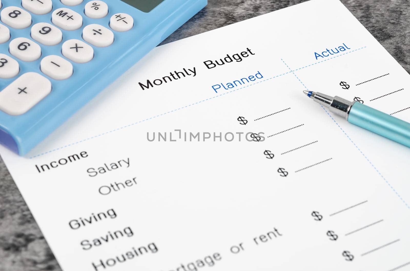 A print out of a monthly budget for your text with pen and calculator on wooden background.