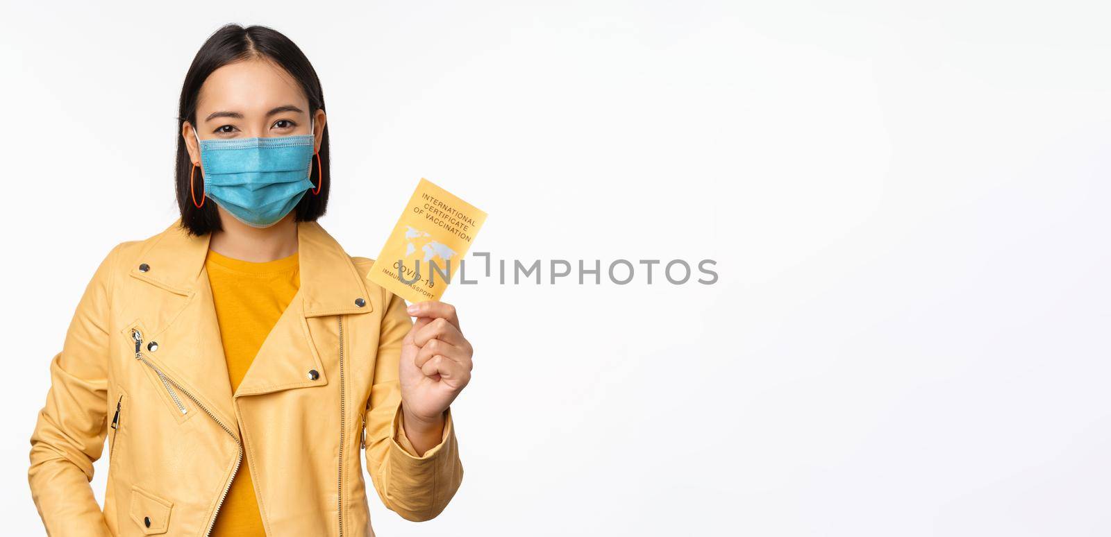 Hey you got point. Cheerful cute asian lively girl dark short haircut pointing camera finger-pistol smiling broadly, encourage friend make move, congratulate coworker good job, stand blue background.