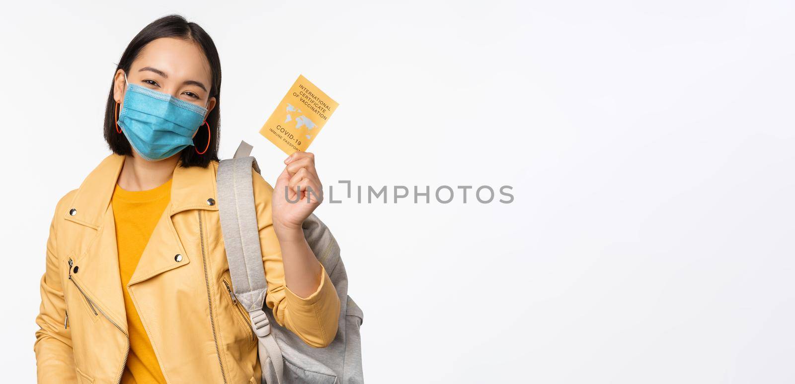 Hey you got point. Cheerful cute asian lively girl dark short haircut pointing camera finger-pistol smiling broadly, encourage friend make move, congratulate coworker good job, stand blue background.