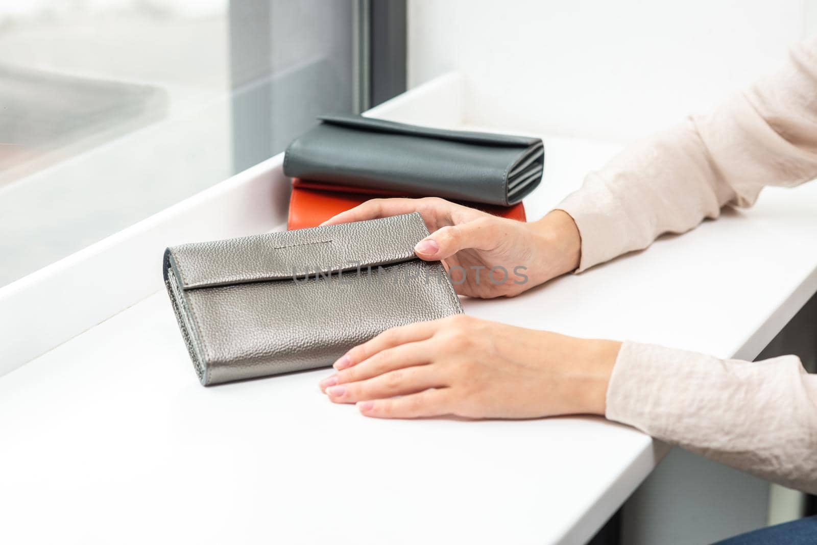 a purse in the hands of a girl on a white table