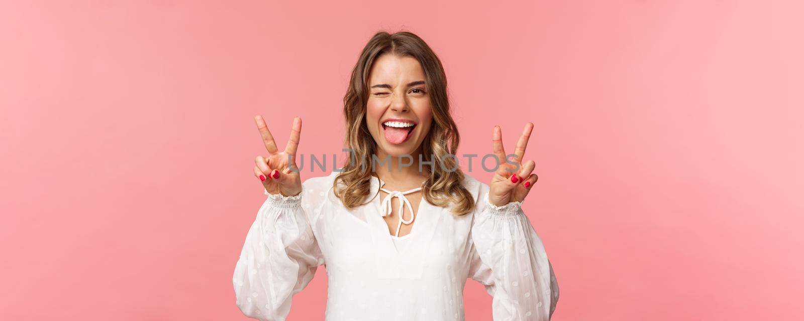 Close-up portrait of carefree good-looking emotive blond girl having fun, showing positivity and joy, enjoying awesome spring day, event or party, show peace sign, stick tongue and wink cheeky.