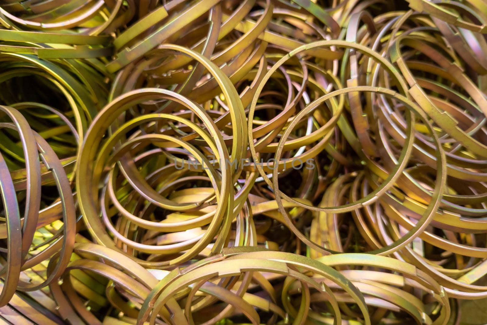 cadmium with chromatization yellow protective coating on steel ring parts pile - full frame close-up background with selectivef focus and blur