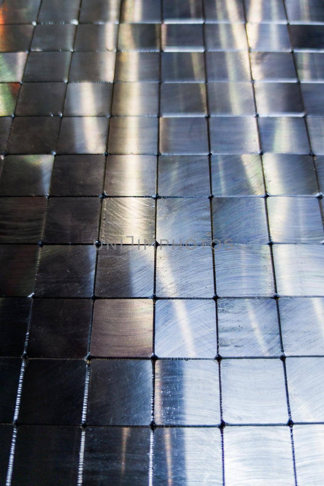 shiny steel machined blocks pavement surface background - close-up with selective focus and blur.
