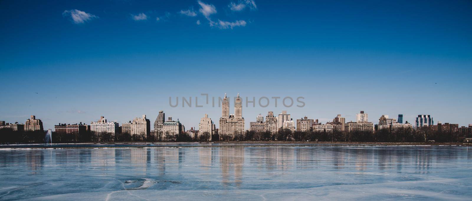 New York City - Panoramic view of modern buildings of upper west side Manhattan from Central Park with Jacqueline Kennedy Onassis Reservoir in winter