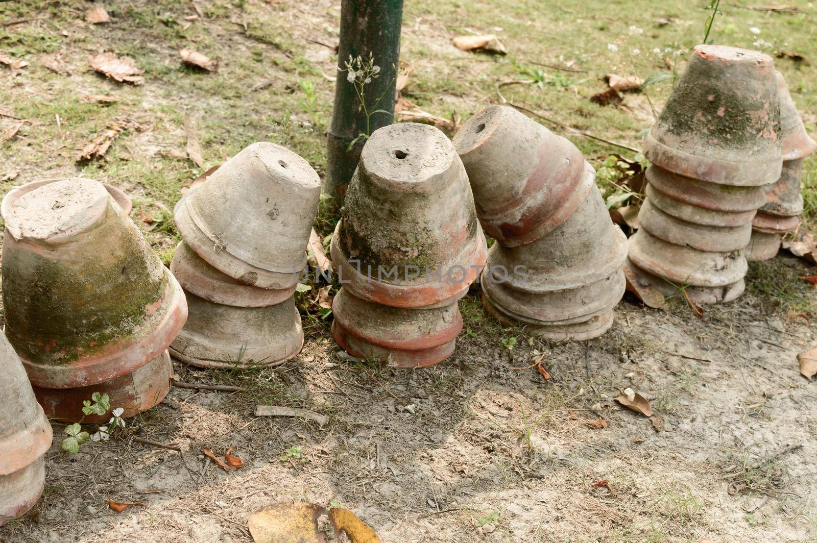 Stack of Earthen flower tubs on garden. Clay flower pots on the garden front yard. by sudiptabhowmick