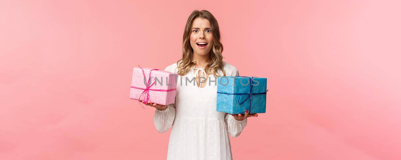 Holidays, celebration and women concept. Portrait of surprised and impressed blond girl didnt expect receive so many presents, holding two wrapped gifts and smiling camera astonished by Benzoix
