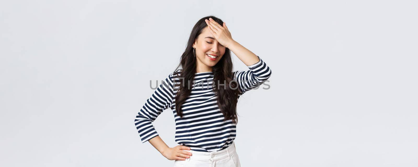 Lifestyle, beauty and fashion, people emotions concept. Awkward laughing asian woman facepalm and close eyes, smiling embarrassed, forgot something or made stupid mistake by Benzoix