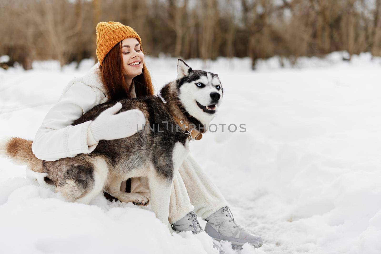 young woman in the snow playing with a dog fun friendship fresh air by SHOTPRIME