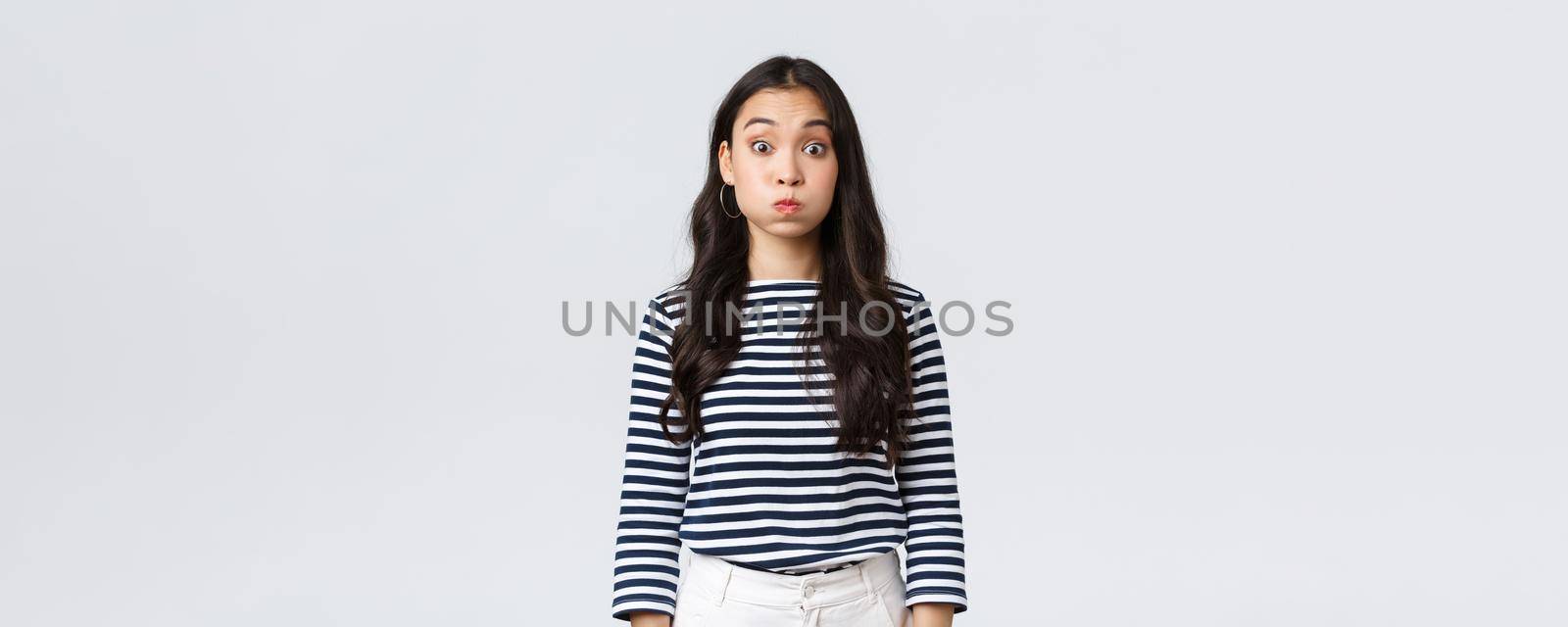 Lifestyle, people emotions and casual concept. Confused cute and puzzled girl pouting, searching for solution, holding breath and staring questioned camera, white background by Benzoix