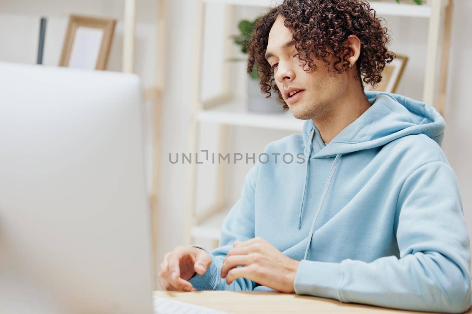 portrait of a man in a blue jacket in front of a computer with phone technologies. High quality photo