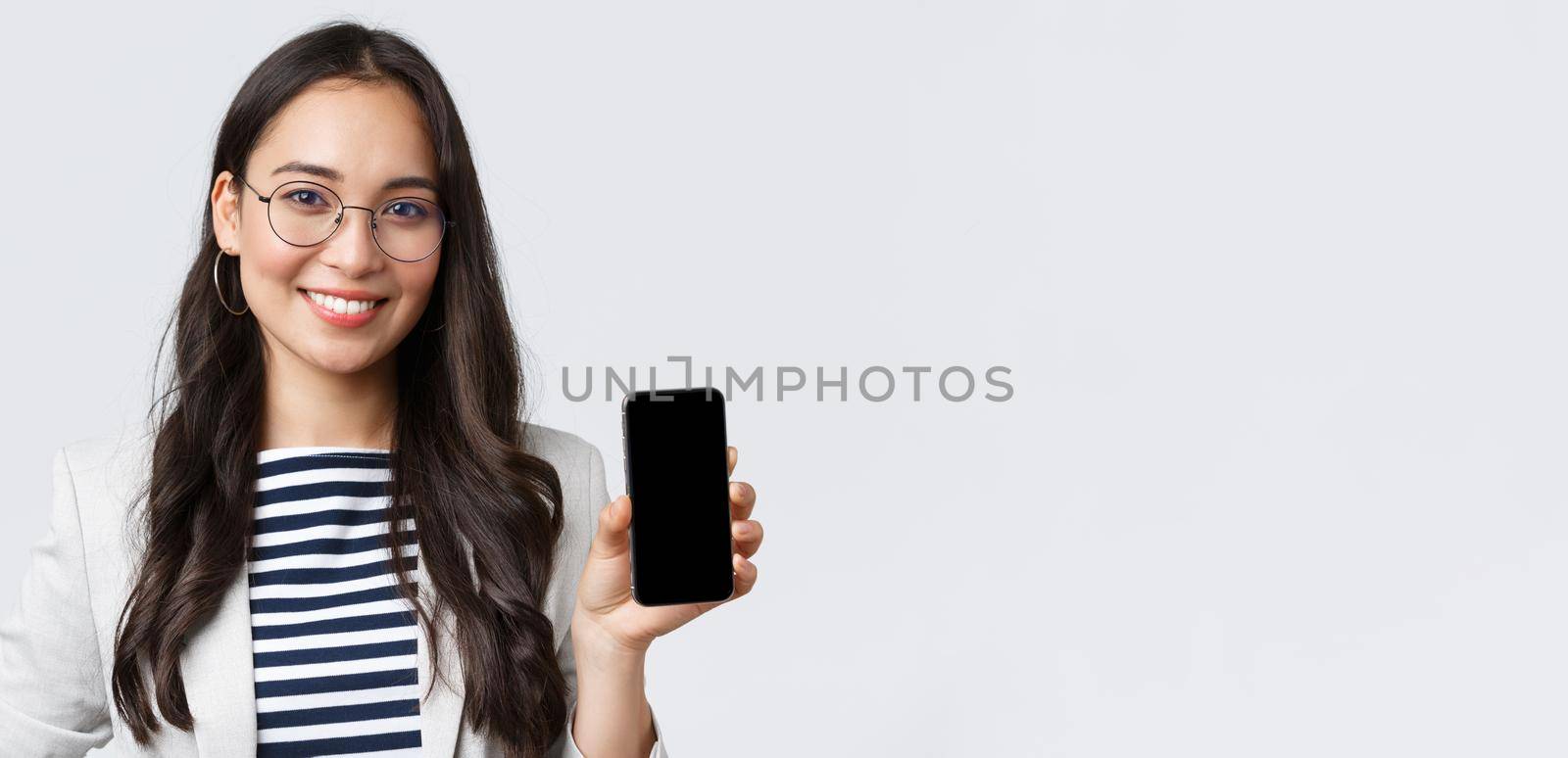 Business, finance and employment, female successful entrepreneurs concept. Close-up of stylish modern asian businesswoman introduce mobile application, showing advertisement in smartphone by Benzoix