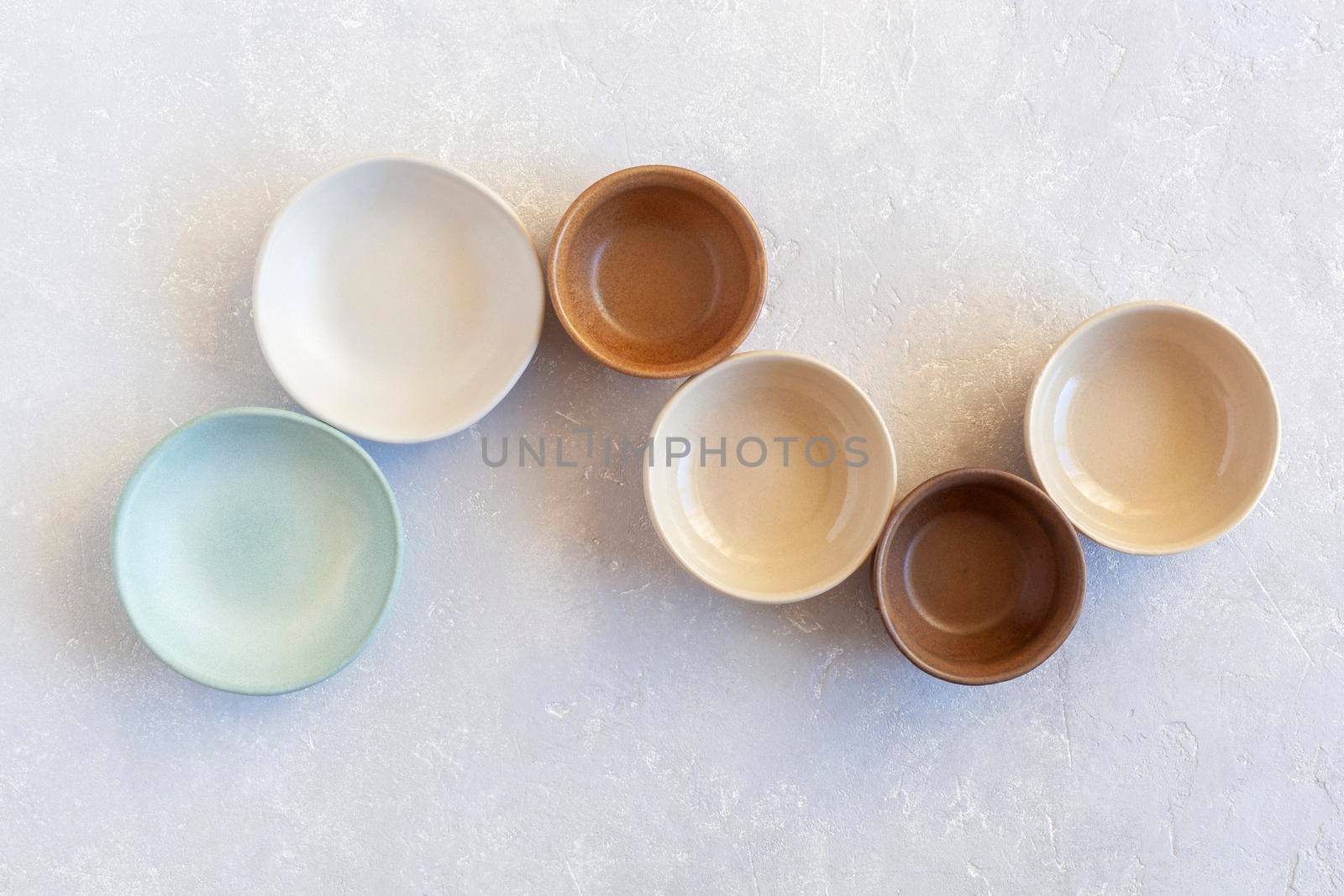 empty ceramic bowls in S-shape form, top view, pastel colors