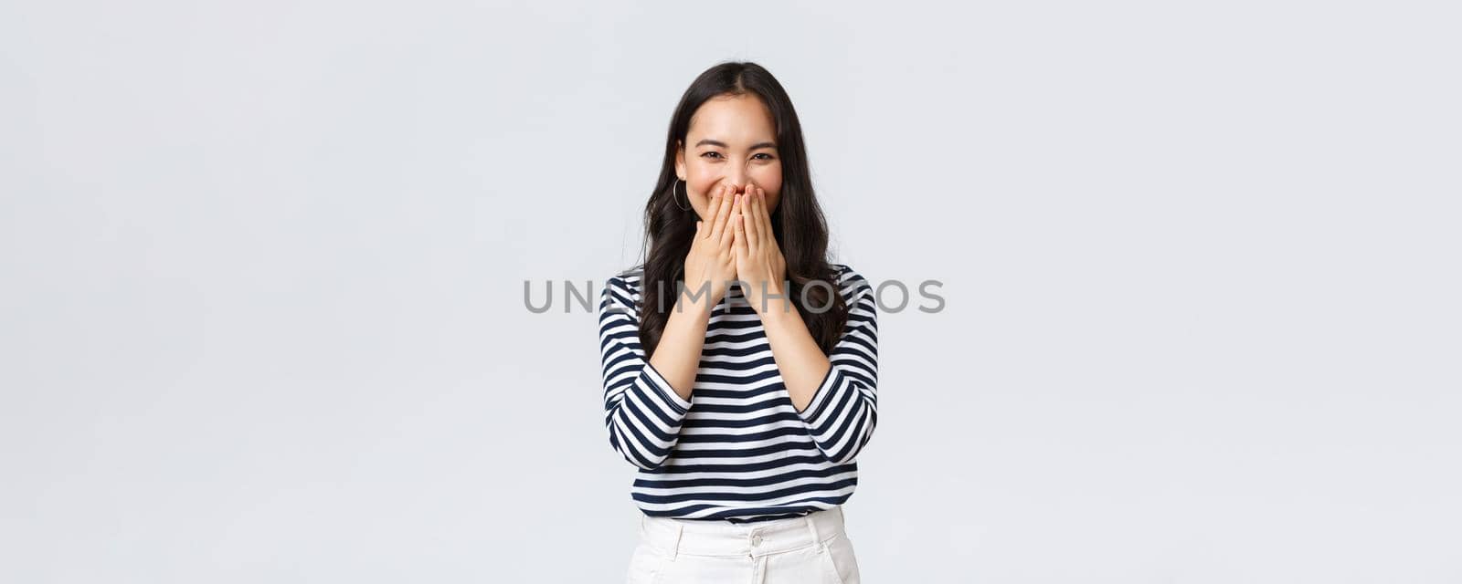 Lifestyle, people emotions and casual concept. Cute silly asian female giggle while gossiping and mocking someone, cover mouth as smiling and laughing carefree.